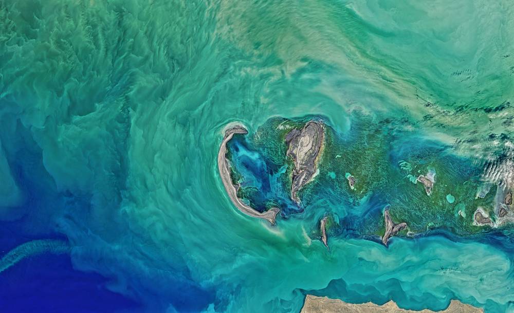 Satellite view of teal coastal water and islands